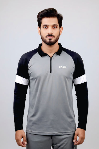 A man modeling a long-sleeve athletic quarter-zip pullover in gray and black with white sleeve stripes, featuring the brand name 'SAAB' on the left chest, set against a light gray studio background.